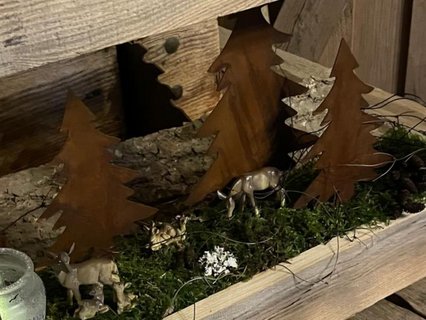 Detailansicht einer Waldszene mit Rehen und Bäumen im Holzrahmen